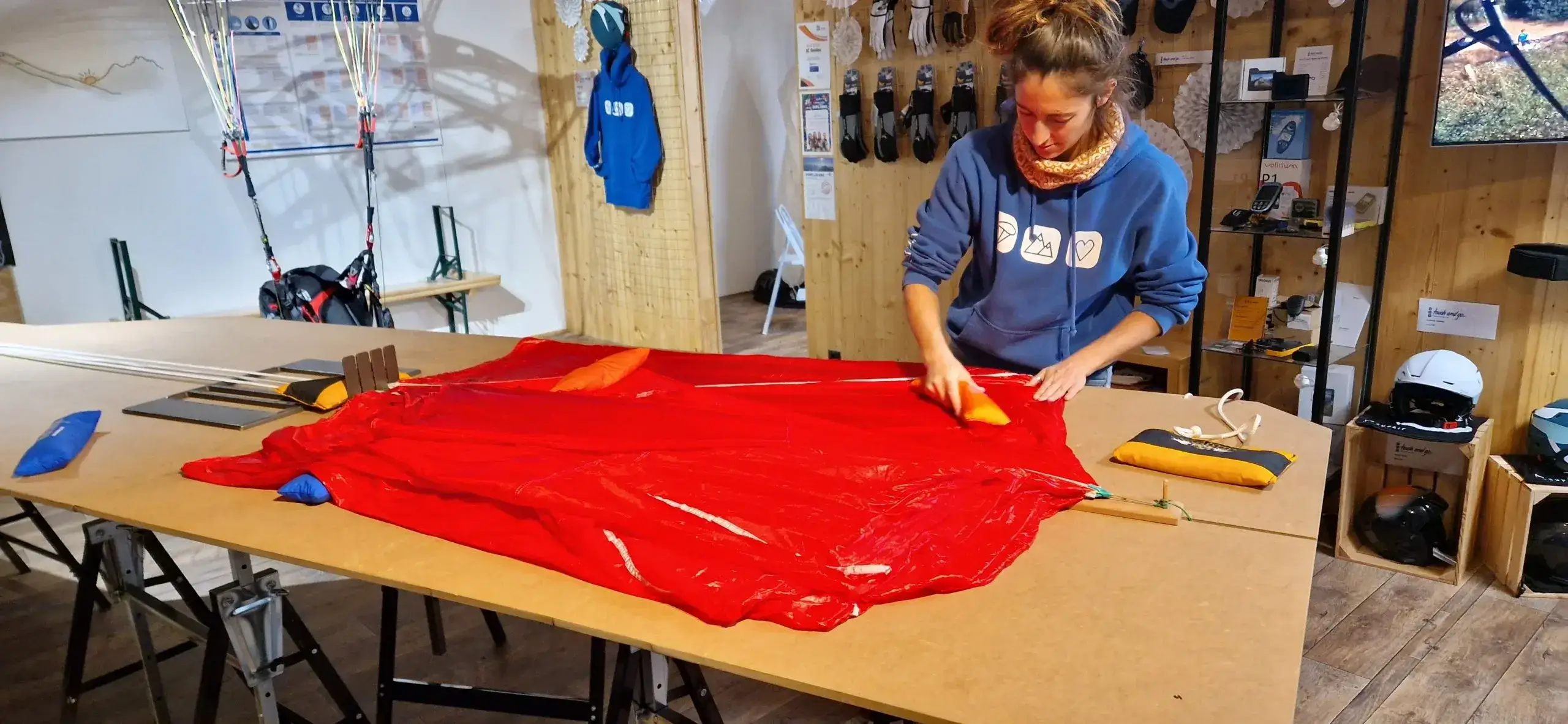 Employee carefully packs an emergency parachute in the store to ensure it is ready for use in an emergency.