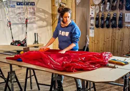 Employee carefully packs an emergency parachute in the store to ensure it is ready for use in an emergency.