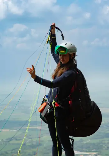 A pilot preparing for take-off. Enjoy the view over the green hills of Colombia during the flight with touch and go Paragliding and Airnomads Colombia.