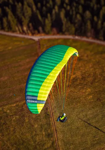 Flügschüler gleitet ruhig mit einem grünen Nova Prion 6 Paraglider – Symbol für den Beginn einer aufregenden Paragliding-Reise bei touch and go Paragliding.