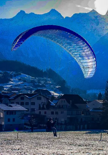 Student pilot on landing approach during training at touch and go Paragliding in central Switzerland.