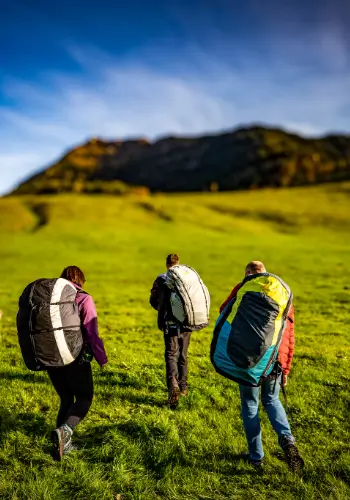 Student pilots on their way to the practice slope during paragliding training at touch and go Paragliding in central Switzerland.