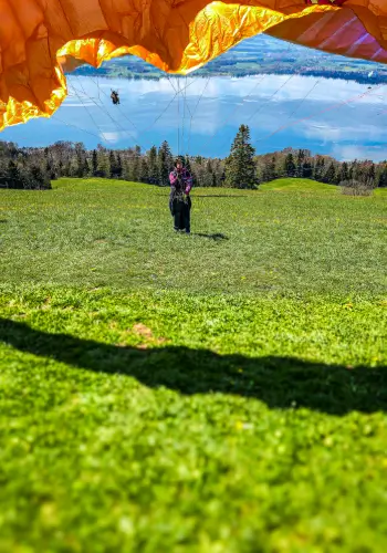 Pilot pulls up the glider to take off on the Zugerberg during paragliding training at touch and go Paragliding in central Switzerland.