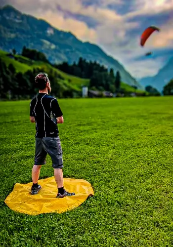 Flight instructor monitors the landing of a student during individual coaching at touch and go paragliding.