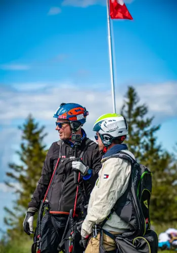 Tandempilot gibt letzte Instruktionen an den Passagier vor dem Start während eines Tandemflugs bei touch and go Paragliding.