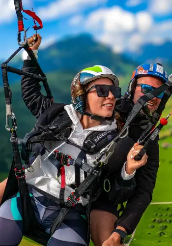 Passagier übernimmt das Steuer während eines Tandemflugs in der Zentralschweiz mit touch and go Paragliding.