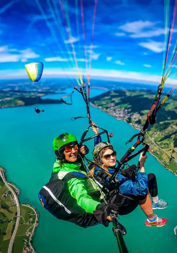 Passenger flies tandem with touch and go paragliding, while her boyfriend flies alongside with his own paraglider.