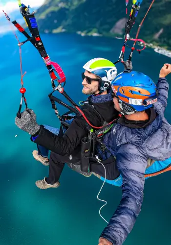 Passenger takes the controls during a tandem flight over Lake Lucerne with touch and go paragliding.