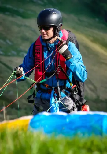 Pilot carefully sorts the lines of his paraglider before take-off during touch and go paragliding safety training.