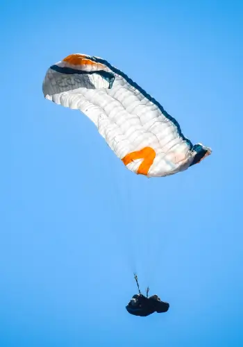 Pilot performs a full stall over the water during safety training at the touch and go paragliding school.