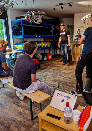 Safety training participants practice and discuss maneuvers on the simulator during the simulation day at touch and go Paragliding in Central Switzerland.
