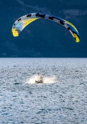 Paraglider makes a controlled landing in the water during safety training on Lake Garda.