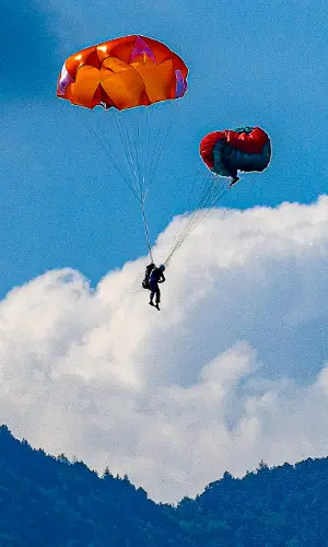 Pilot throws his emergency parachute over the water during touch and go paragliding safety training.