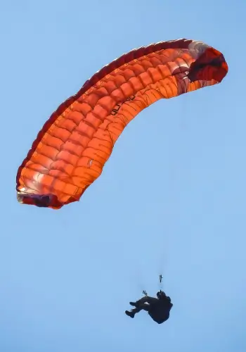 Pilot performs a full stall over the water during safety training at the touch and go paragliding school.