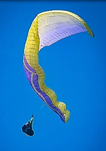 Pilot simulates a side collapse during touch and go paragliding safety training on Lake Garda under the guidance of experienced instructors.