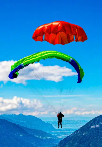 Pilot throws his emergency parachute over the water during touch and go paragliding safety training.