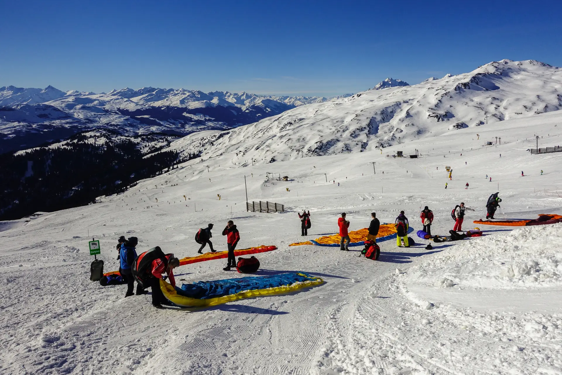 Paraglider pilots enjoy the season opening flight in Laax with touch and go paragliding.