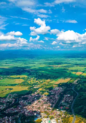 Paragliding pilots fly over the picturesque landscapes of the Valle de Cauca in Colombia during a trip with touch and go paragliding.