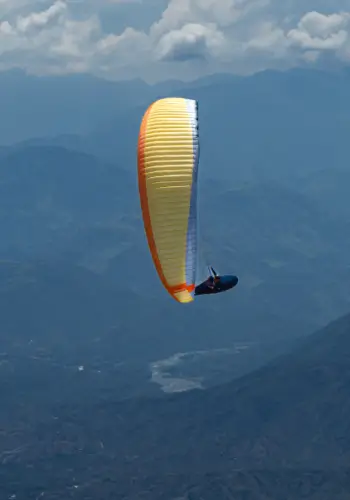 Gleitschirmpilot mit einem Nova Codex fliegt Thermik in Santafe während einer Kolumbienreise mit touch and go Paragliding.