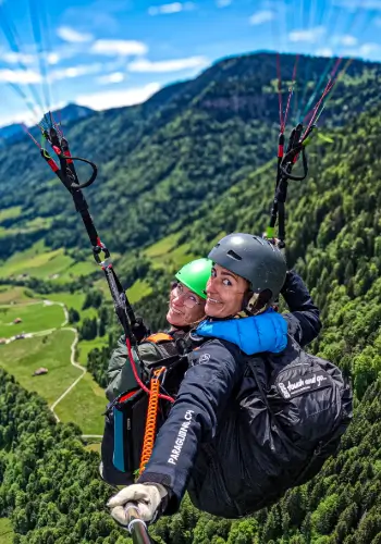 Tandem flight passenger and pilot float gently from Rigi Scheidegg. An unforgettable view of the Alps, Lake Zug and Lake Lauerz.