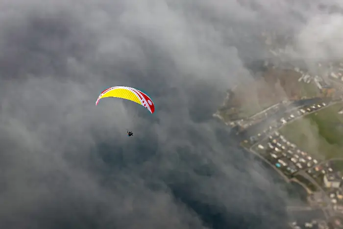 Tandempilot und Passagier schweben sanft über den Urmiberg und geniessen den Panoramaausblick auf den Vierwaldstättersee und die Zentralschweizer Alpen.