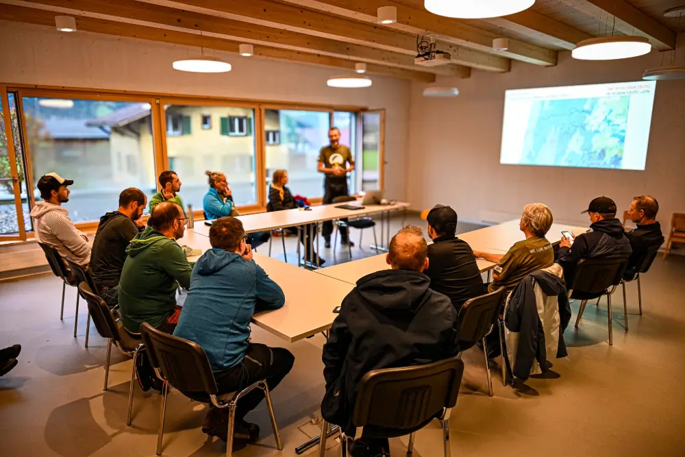 Der Organisator gibt beim Briefing letzte Anweisungen an die Teilnehmer des Hike & Fly Wettkampfs.