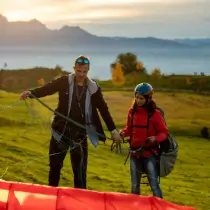 Touch and go instructor checks the lines of a paraglider on the practice slope during training.