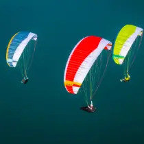 Nova Prion paragliders fly high above the sea.