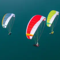 Nova paragliders fly high above the sea.