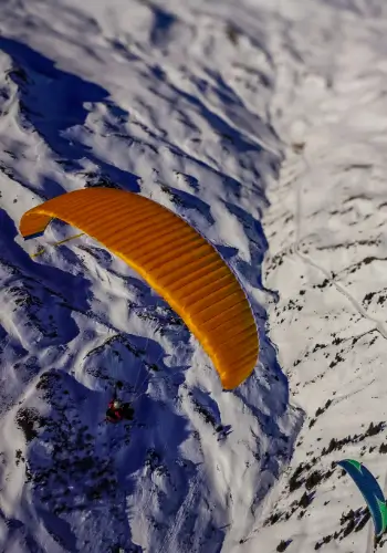 Paraglider pilots enjoy the season opening flight in Laax with touch and go paragliding.