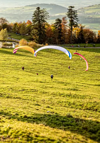 Three students go down the practice slope with their Phi paragliders - a moment of full control