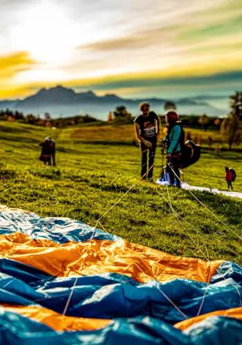 Flight instructor helps a paragliding student prepare for take-off on the practice slope to ensure a safe and successful take-off.
