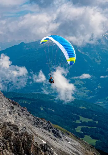 Ein Schüler fliegt mit seinem Nova Gleitschirm über die malerische Landschaft ver Zentralschweiz während eines Trainingflugs.