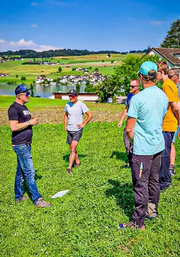 Ein Fluglehrer führt ein Debriefing mit den Flugschülern am Ende des Flugtages durch, um Erfahrungen zu reflektieren und wichtige Erkenntnisse zu besprechen.
