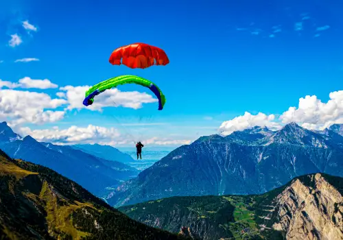 Pilot throws his emergency parachute over the water during touch and go paragliding safety training.