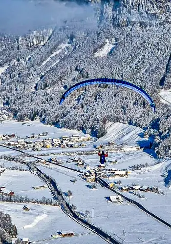 Ein Schüler fliegt mit seinem Nova Gleitschirm über die malerische Landschaft von Wolfenschiessen während eines Trainingflugs.