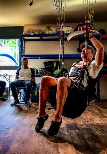 Der Fluglehrer zeigt. beim Manöverbriefing im Simulator während der Ausbildung bei touch and go Paragliding die Manöver vor.