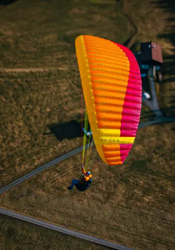 Gleitschirm fliegt nahe über dem Boden kurz vor dem Endanflug während der Ausbildung bei touch and go Paragliding - der Flugschule in der Zentralschweiz.