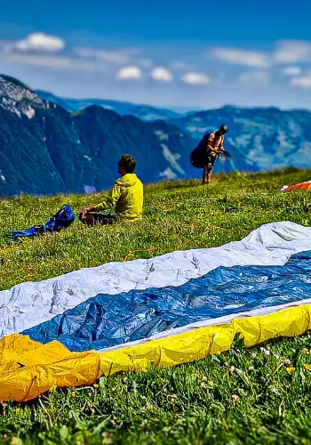 Flugschüler sitzt auf dem Startplatz und bereitet sich mental auf seinen Flug vor, während der Ausbildung bei touch and go Paragliding.