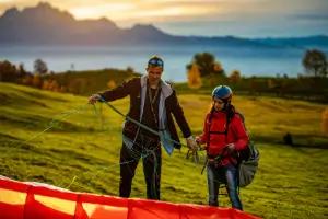 Flight instructor checks the lines of a paraglider on the practice slope during training at touch and go paragliding.