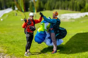 Student pilots have fun at the landing site after a successful landing with touch and go paragliding.