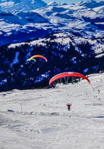 Paraglider pilots enjoy the season opening flight in Laax with touch and go paragliding.