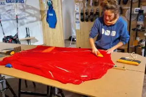 Employee carefully packs an emergency parachute in the store to ensure it is ready for use in an emergency.