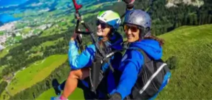 Tandem flight in the Schwyz valley basin with touch and go paragliding - the passenger enjoys the view of the beautiful landscape.