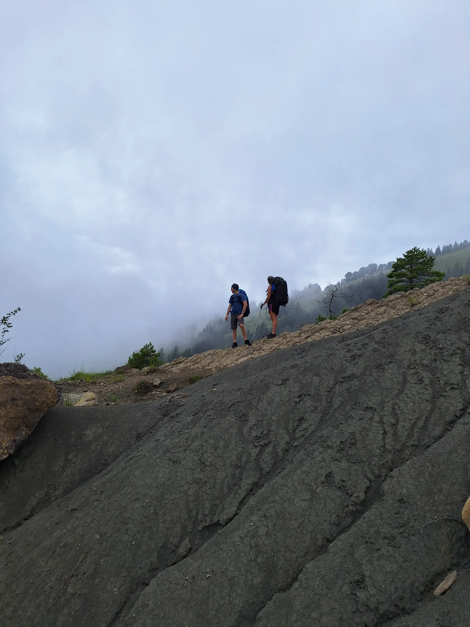 Hike & Fly Piloten auf dem Panoramaweg zum Gnipen-Startplatz in der Zentralschweiz, felsige Passagen und atemberaubende Aussicht.